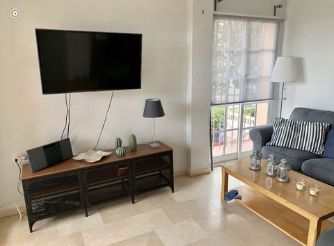 Living room with open plan modern kitchen and table and chairs and air con unit 