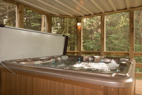 Relaxing hot tub in a beautiful setting in a screened in porch.