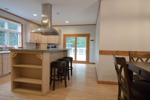Kitchen has island with seating for 3 adjacent to the table for 6.