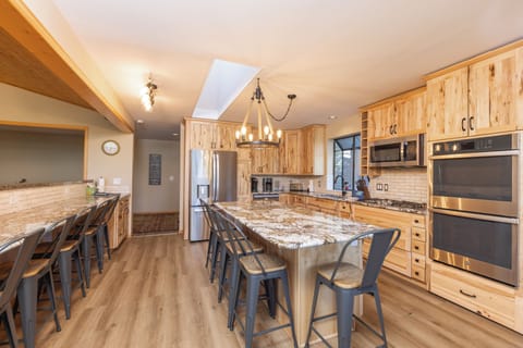 Open kitchen with stainless steel appliances and breakfast table