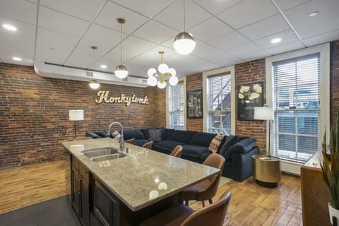 - Bright open layout with large sectional and Nashville wall sign for added vibe - Brick walls and modern lighting create a stylish living area for guests - Ideal social space for relaxing nights and group hangouts in the city