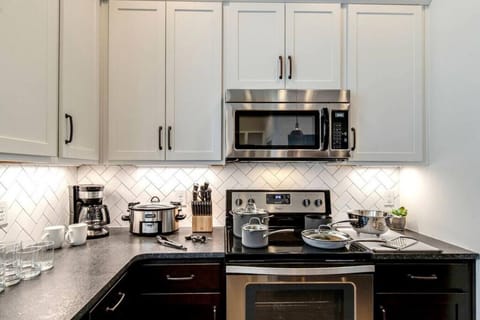 Fully equipped kitchen with stainless steel appliances, drip coffee makers, and kitchen island with additional seating