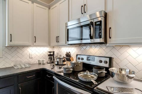 Fully equipped kitchen with stainless steel appliances, drip coffee makers, and kitchen island with additional seating