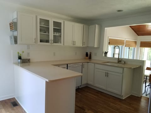 Kitchen overlooks dining room, steps from side yard with grill & outdoor seating