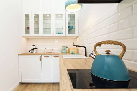 Modern kitchenette with white furniture.