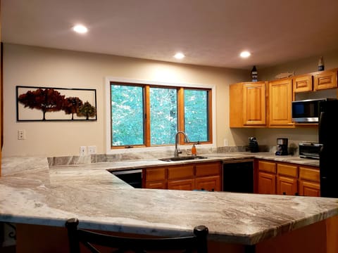 Fully equipped kitchen with fridge, range, dishwasher, microwave, and Keurig.