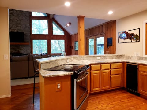 The granite bar ties the den and kitchen together. Plenty of natural light.