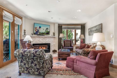 Comfortable living area with plenty of seating, bright natural light and electric fireplace.