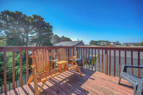 Relax on your private wooden deck with comfortable Adirondack chairs, where warm sunlight and peaceful neighborhood views create the perfect spot for morning coffee.