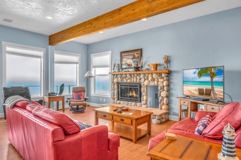 Sink into plush red leather sofas by your crackling stone fireplace, where exposed beams and lake views create the perfect retreat.