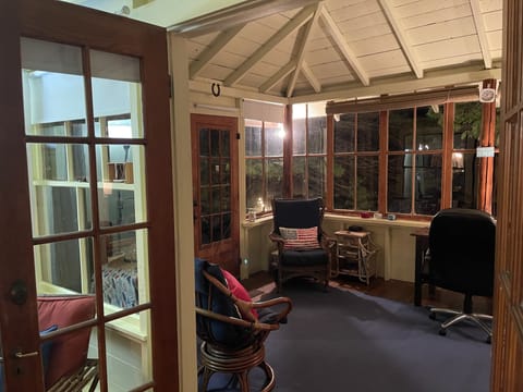 Sun porch at night. Door opens to stairs down to deck and waterfront. 