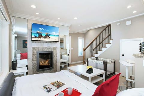 Sophisticated living room design with a sofa that opens up to full-size beds, 55” Smart TV, office/kitchen seating, beautiful decor, and much more.