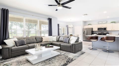 Bright and modern open-concept living space with a cozy sectional and sleek kitchen!