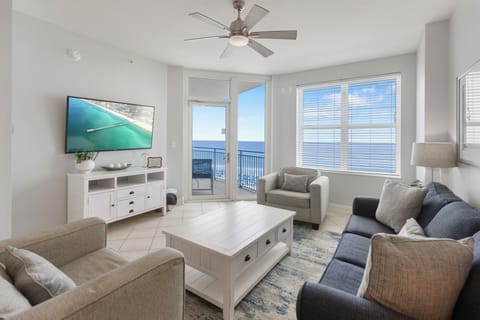 Unwind in your bright living room with plush seating and stunning ocean views through floor-to-ceiling windows.