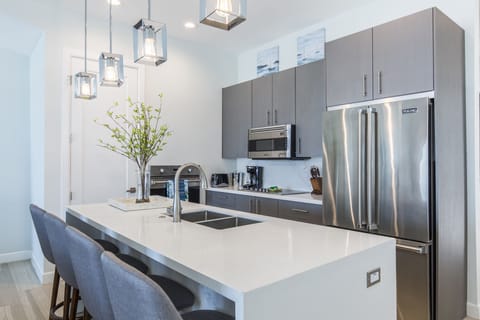 Fully stocked kitchen equipped with stainless steel appliances and a large center island.