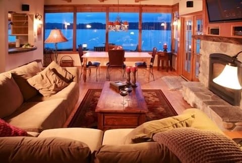 The living room is warmed by a beautiful river rock fireplace