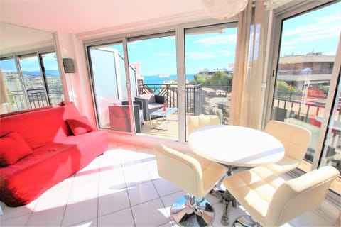 living room with sofa and dining table opening onto a terrace and nice sea view