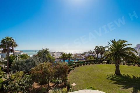 Panoramic sea views from Seaview Apartment H in Praia da Luz, overlooking palm trees, rooftops, and the sparkling Atlantic Ocean on the Algarve coast