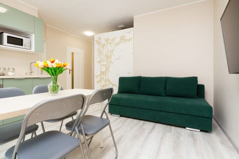 Living room with a Smart TV, sofa bed and dining area with kitchenette.