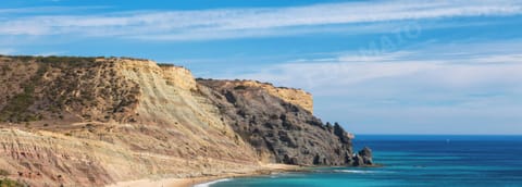 Stunning golden cliff coastline near Praia da Luz in the western Algarve, showcasing the dramatic rock formations and turquoise sea that make this area a top holiday destination