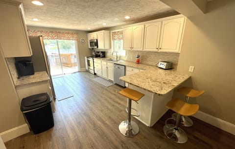 Kitchen overlooks pool deck and patio area.