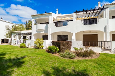 Well-maintained landscaped gardens with lawns and white-washed Algarve-style apartments at the Pampas resort near Alvor, Portugal