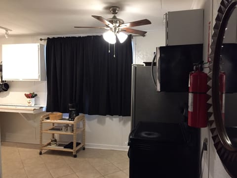 ceiling fan above refrigerator, stove and microwave