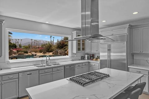 The heart of the home is stunningly designed with an oversized island, professional-grade appliances, and one of the most breathtaking kitchen views in the Coachella Valley.