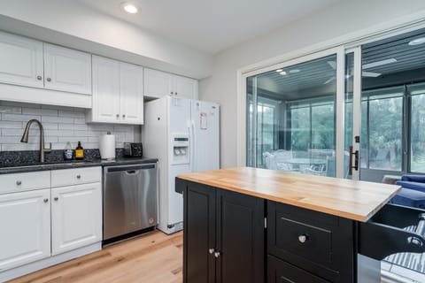 Center island has two stool.  Sliders from kitchen lead out to the sunroom