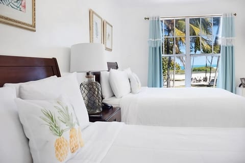 Sink into soft linens and watch waves through the window.