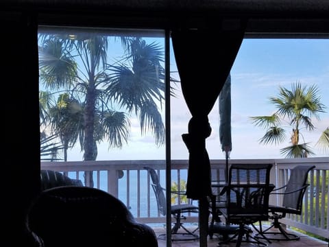View of deck, overlooking Atlantic ocean, from inside, thru sliding glass doors