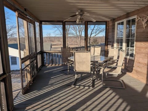 Spacious screened-in deck with outdoor dining at Pond View Loft. Gather around the table to enjoy fresh air, country views, and peaceful mornings or evenings — all protected from the elements for year-round comfort.