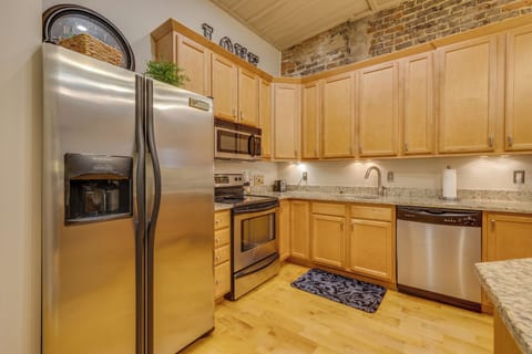 This loft is perfect for cooking enthusiasts as it boasts a spacious kitchen workspace and a cozy bar seating area.
