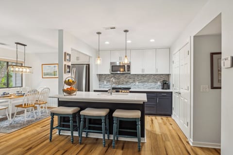 Kitchen featuring stainless steel appliances and plenty of storage. The kitchen also features 3 barstools.