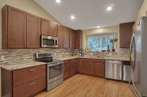 Large kitchen with granite counter tops and stainless steel appliances.