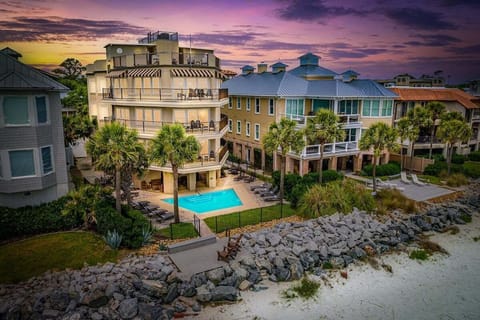 Aerial view of beachfront property with pool at sunset