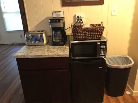 Kitchen area with coffee maker, toaster, microwave, and mini fridge