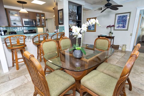 The dining area sits adjacent to the lanai, offering a seamless indoor-outdoor flow for family meals with ocean air drifting in.