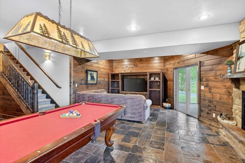 Full sized pool table in the lower-level living room with access to the screened in porch