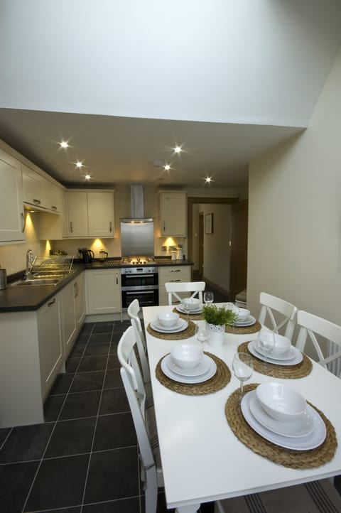 Fully fitted kitchen with dining table leading off to sun-room