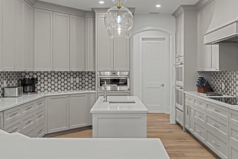 Beautiful white chef's kitchen with a breakfast bar and state-of-the-art appliances.