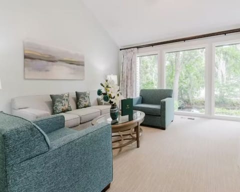 Relax in the sunlit lounge with garden views and cozy seating.