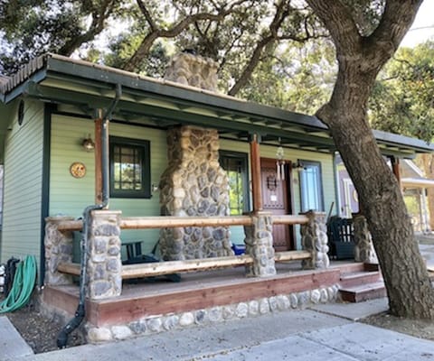 Exterior resembles a log cabin, with a faux stone chimney and log porch railings