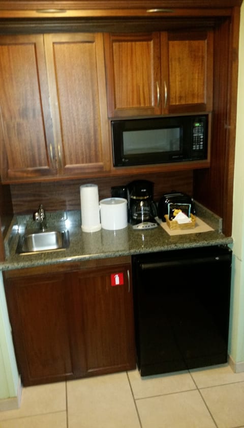 Mini-kitchen in third bedroom has extra dishes/cutlery in cabinets.