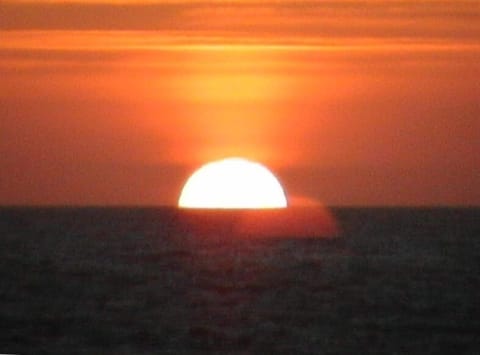 Sunset, from your windows. Go to the beach or watch the beauty from the couch.