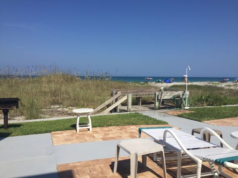 Deck overlooking ocean w/ chairs, tables and 2 BBQ grills