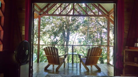 Large glass doors open to balcony with sitting are with tree house like views!