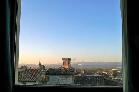 A romantic sunset and moon above Sansepolcro's rooftops from the bedroom window