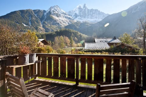 Large balcony off living area with outdoor dining furniture and BBQ in summer