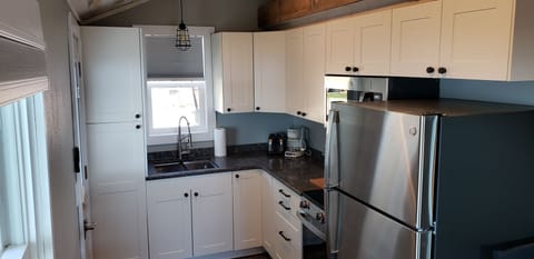 full kitchen including stainless steel appliances, quartz countertop.